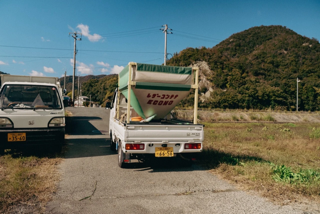 山と田んぼに囲まれた農作業の軽トラック